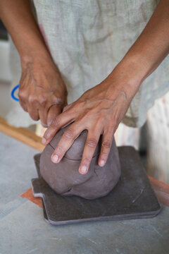Potter cutting clay with wire 