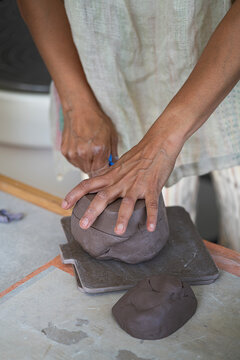 Potter cutting clay with wire 