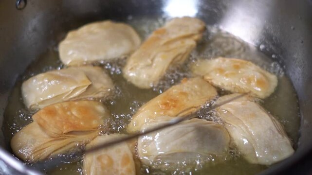 Deep Frying Traditional Puri Famous Pheni Khaja in Hot Oil Kadhai Pan. Sizzling Deep Fried Food: Traditional Indian Sweet Khaja Pastry in Hot Oil.