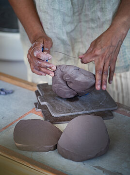Potter cutting clay 