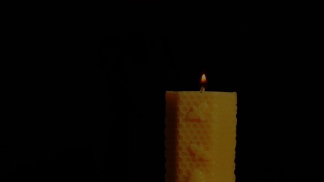Hand Lighting a Natural Beeswax Honeycomb Candle in a Dark Moody Room with Copy Space
