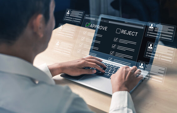 Business Professional Using Laptop to Review Applications with Approval and Rejection Options on Screen in Modern Office Environment. Bitwise.