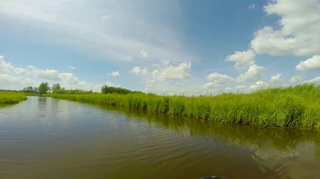 Point of view of a boat boat cruising through Dutch channels, Netherlands