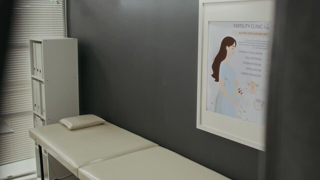Empty fertility clinic examination room showing in vitro fertilization poster on wall and medical bed. Clip serves as perfect visual for healthcare marketing and reproductive medicine promotion
