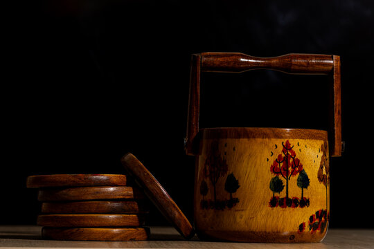 Handcrafted Wooden Coaster Set with Painted Caddy on a Dark Background with Copy Space