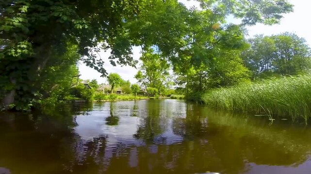 Point of view of a boat boat cruising through Dutch channels, Netherlands