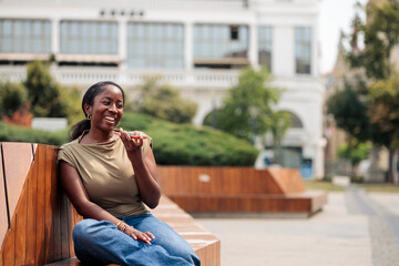 Fototapeta premium Woman sending voice message on phone in city park