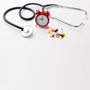 stethoscope and pills on white background