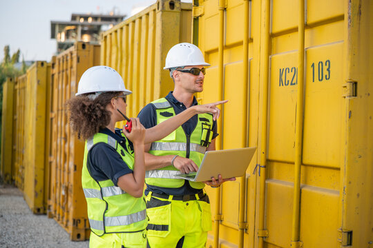 Logistics workers inspecting cargo operations at an industrial freight yard, promoting supply chain management, shipping, teamwork and workplace safety.