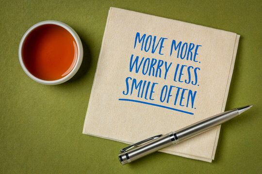 Move More. Worry Less. Smile Often. &ndash; inspirational handwritten note on a napkin with tea and pen, promoting wellness, happiness, movement, and a positive lifestyle.