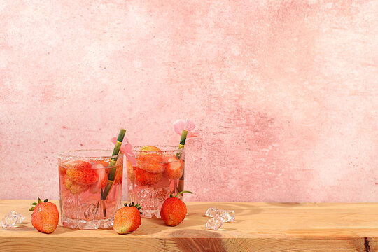 Festive alcoholic cocktail, pink martini in glasses on a bright background with strawberries, summer bar concept, alcoholic drinks at a party, restaurant and cafe advertising, modern still life