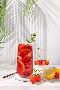 Strawberry Iced Tea or Mint Lemon Cocktail is a refreshing summer drink recipe. Glasses with berry fruit lemonade on a light concrete table, detox diet and weight loss concept, restaurant menu.