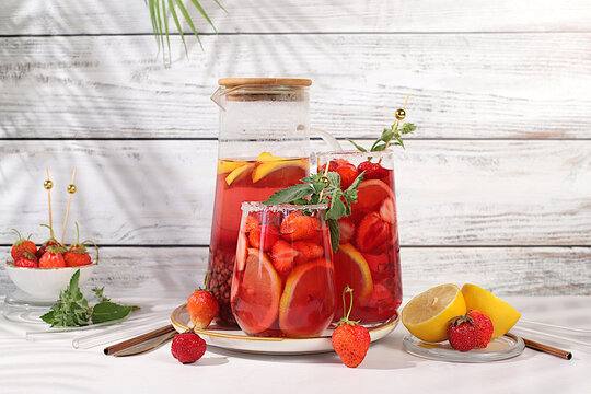 Refreshing summer homemade lemonade cocktail and non-alcoholic mojito, strawberry iced tea with berries, mint and lemon, weight loss concept, detox water with fruit flavor on light background.