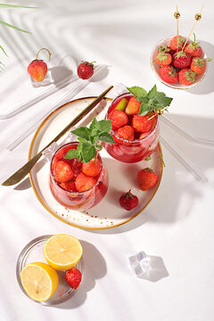 Refreshing summer homemade lemonade cocktail and non-alcoholic mojito, strawberry iced tea with berries, mint and lemon, weight loss concept, detox water with fruit flavor on light background.