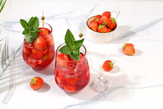 Refreshing summer homemade lemonade cocktail and non-alcoholic mojito, strawberry iced tea with berries, mint and lemon, weight loss concept, detox water with fruit flavor on light background.