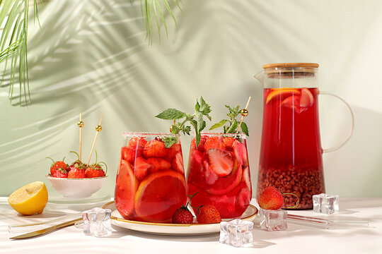 Refreshing summer homemade lemonade cocktail and non-alcoholic mojito, strawberry iced tea with berries, mint and lemon, weight loss concept, detox water with fruit flavor on light background.