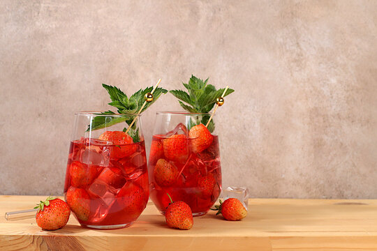 Refreshing summer homemade lemonade cocktail and non-alcoholic mojito, strawberry iced tea with berries, mint and lemon, weight loss concept, detox water with fruit flavor on light background. 