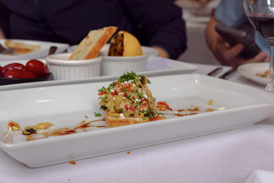 Bruschetta appetizer served at restaurant table with red wine