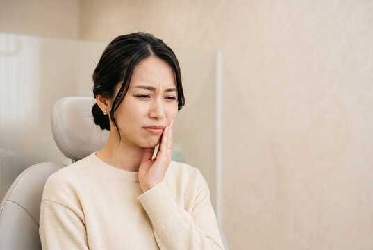 歯科医院の診察台で歯痛に苦しむ日本人女性 Generative AI