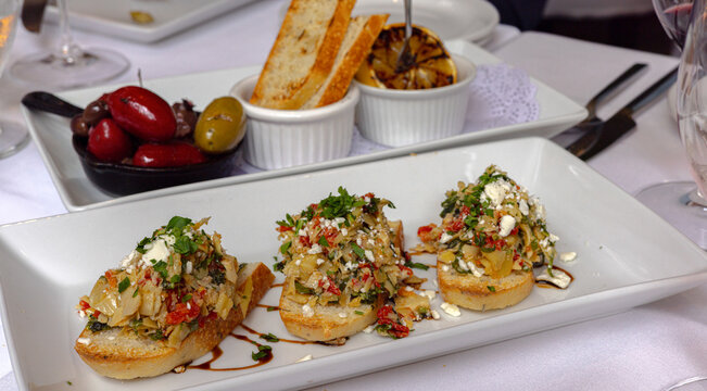 Mediterranean appetizer spread with bruschetta, olives and grilled lemon