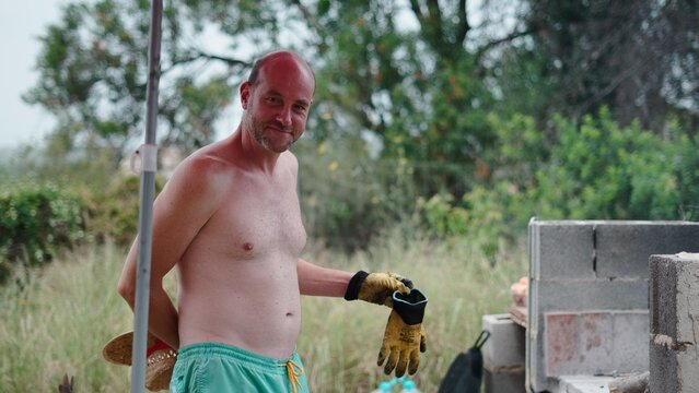 Man smiling outdoors, getting ready for cooking or garden work