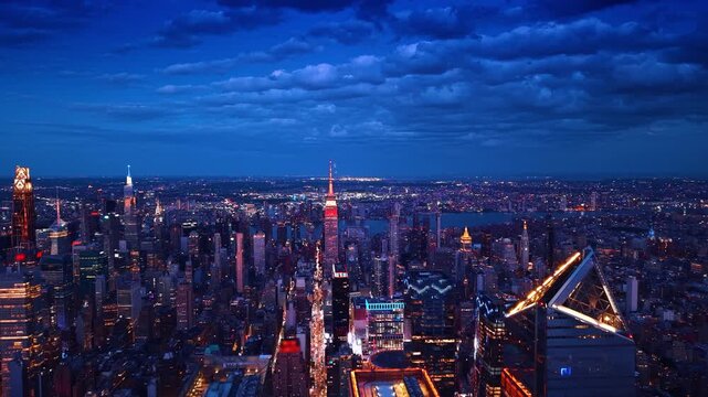 Night panorama of gorgeous New York City, USA under the cloudy sky. Drone flight over luminous skyscrapers in Manhattan.
