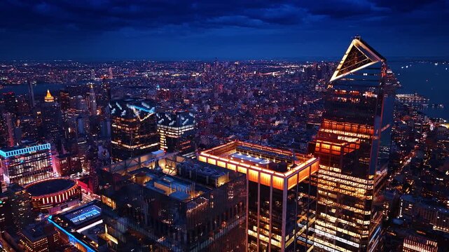 Gorgeous glossy skyscraper with beautiful illumination. Vast panorama of New York City, USA at night from drone.