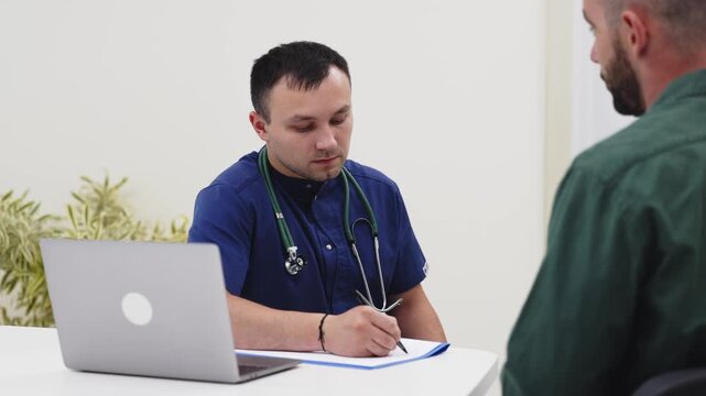 Medical consultation between a family physician and a young man in a modern clinic. Concept primary healthcare, preventive medicine, patient care, medical services, trust.