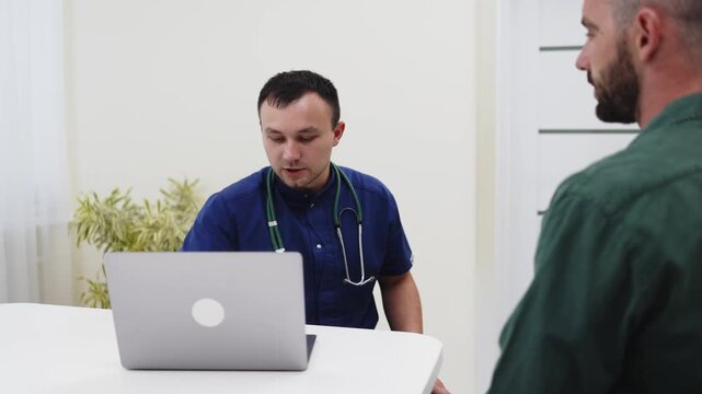Young man receiving a medical consultation from a family doctor using digital health records. Concept patient care, healthcare technology, medical consultation, preventive medicine, family practice.