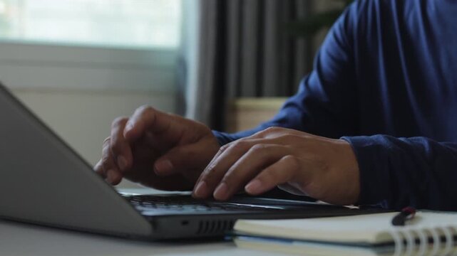 Closeup of a man's hands typing on laptop keyboard, representing remote work, digital communication, online business, content creation, and modern technology workspace in a professional environment.