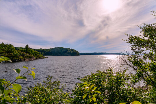 Serene Georgian Bay view from Parry Sound, Ontario, with lush foliage and sparkling waters under a bright sky.