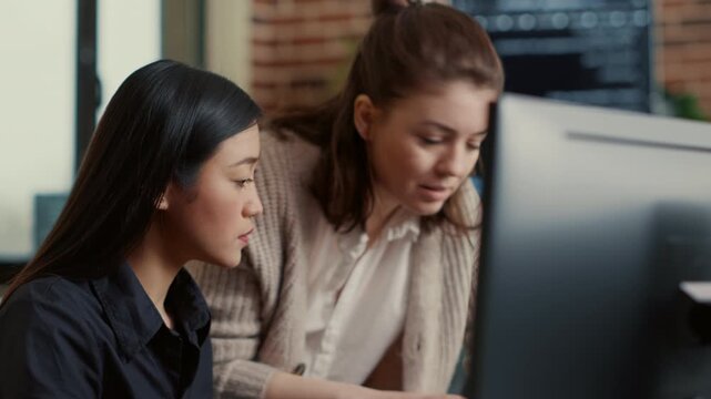 Software development team analyzes a coding project together, using laptop and monitor displays to coordinate software development tasks, inside an algorithm testing setup.
