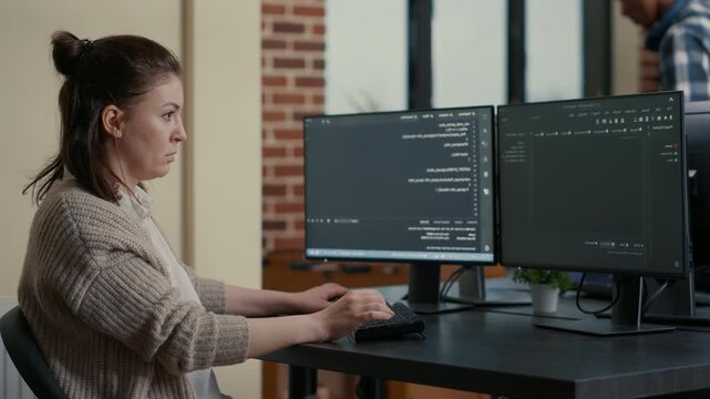 Software developer develops software at a computer desk, connecting source code, database work and digital workflow, while reviewing algorithm output.