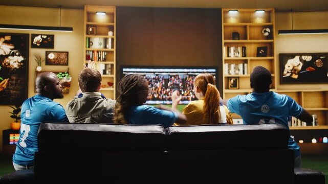 Upset football fans feel annoyed after a missed chance in the living room while a soccer match broadcast plays on the television set.