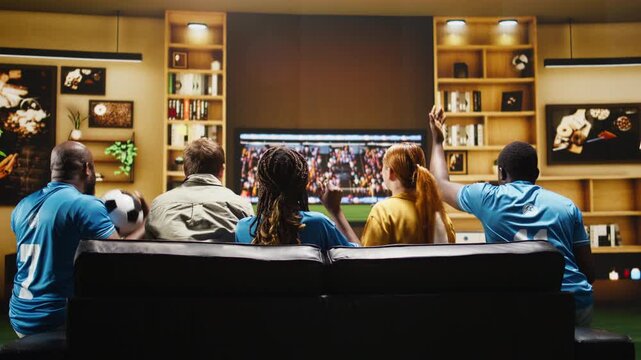Football fans react with frustration to a close call on TV while upset supporters watch a tense live game from the living room couch.