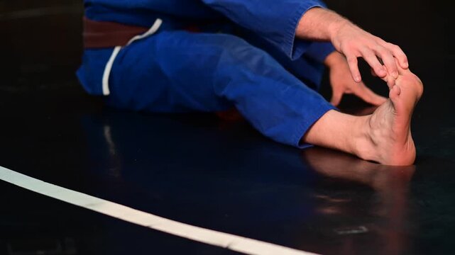Martial arts kimono Gi judo brake fall drill, martial artist practicing striking traditional, brown belt, blurred out background video, selective focus cinematic, gym setting