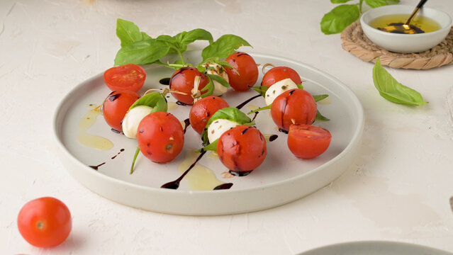 Caprese skewers with cherry tomatoes and mozzarella drizzled with balsamic glaze