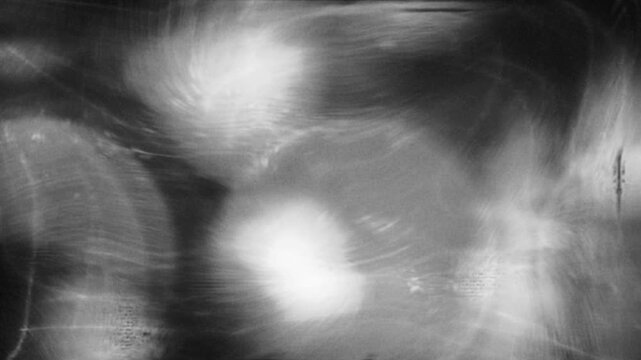 Abstract monochrome footage featuring chaotic light streaks and flickering dynamic patterns in motion.