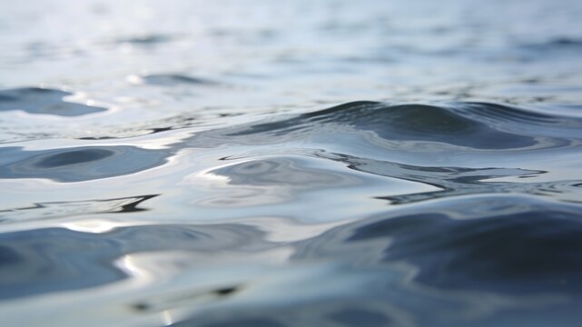 A serene close-up of gentle blue water ripples reflecting soft daylight, creating a peaceful abstract texture of an aquatic surface.