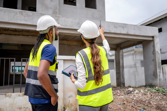 Civil construction managers inspecting unfinished residential building project with civil engineer, checking house construction project, Concept of property inspection scene for housing development.