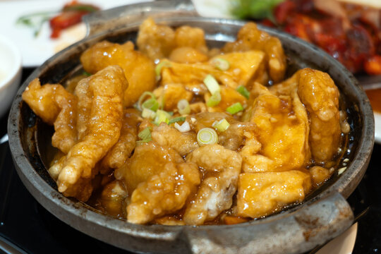 Chinese clay pot tofu with crispy fish fillet, silky tofu, and rich savory brown sauce, garnished with fresh scallions. A comforting Asian dish served hot in a traditional clay pot.