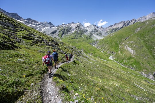 Three mountaineers on a hiking trail, view of rocky mountain peaks in the Karbach valley with Tredebergspitze, Las&ouml;rling H&ouml;henweg, Las&ouml;rling Group, Hohe Tauern National Park, East Tyrol, Tyrol, Austria