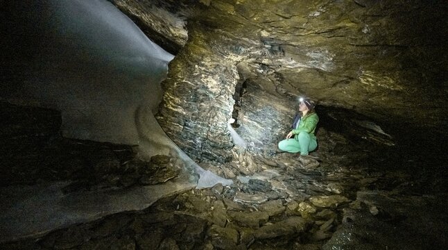 Hiker explores Obstans ice cave in Alta Pusteria, Carnic Alps, East Tyrol, Austria