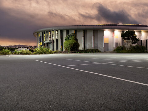 Car background, automotive backplate, empty car parking garage or parking area at dusk with artificial light