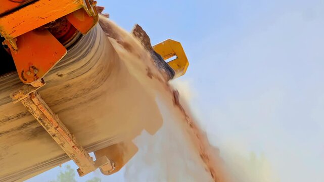 Broken particles falling from conveyor belt of stone crusher low angle slow motion.