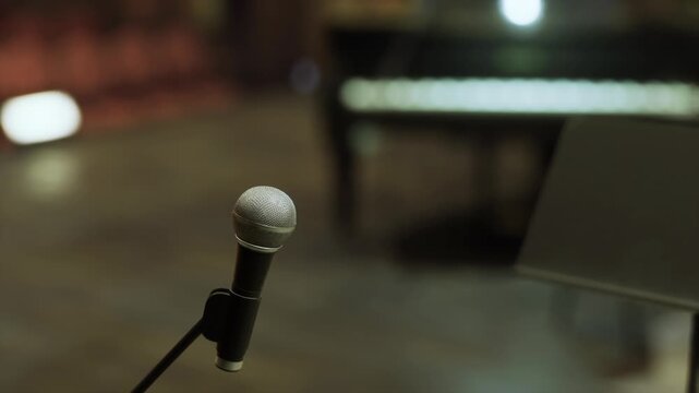 Ready microphone angled toward empty stage and music stand, soft backlight and wooden floor set scene for poetry reading or spoken word open mic quiet tension