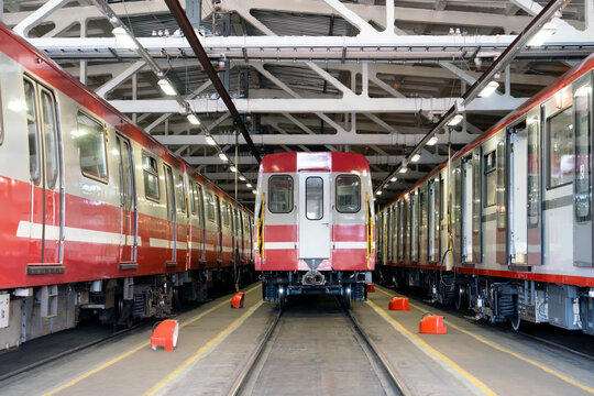 Metro subway trains in a depot above a repair pit, industrial front view hangar.