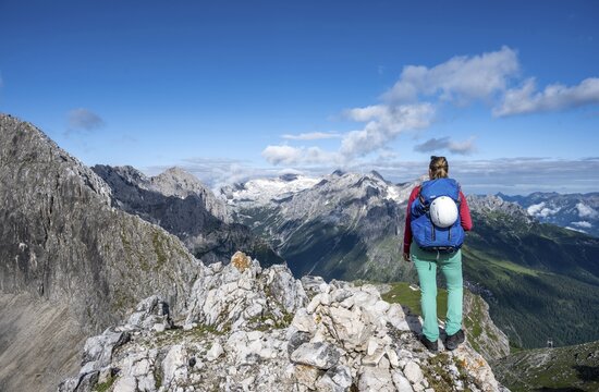 Hiker on a summit, Westliche T&ouml;rlspitze, mountains in dramatic clouds, middle Zugspitze, Wetterstein Mountains, Garmisch-Partenkirchen, Bavaria, Germany