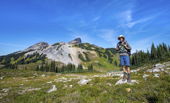 Hiker looking at camera, Black Tusk volcanic mountain, Garibaldi Provincial Park, British Columbia, Canada