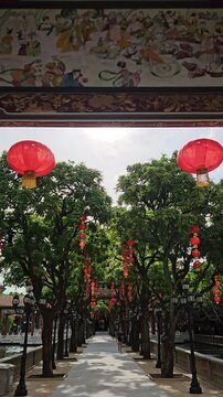 Vertical tilt down shot from a painted heritage ceiling to red lanterns, Baomo Garden, Guangzhou.